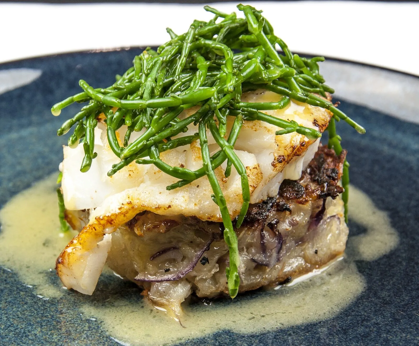 Pan fried cod with classic beurre blanc sauce. This is a fantastic recipe and very versatile with how it can be served. I placed the cod on a potato rosti and topped it with samphire. Seafood with vegetables from the sea. Yum! | https://theyumyumclub.com