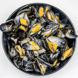 Mussels with white wine, garlic, parsley and cream. A classic moules mariniere recipe. This such a tasty seafood dish and so simple to make. If you ignore the cream it's even healthy ????!! | https://theyumyumclub.com