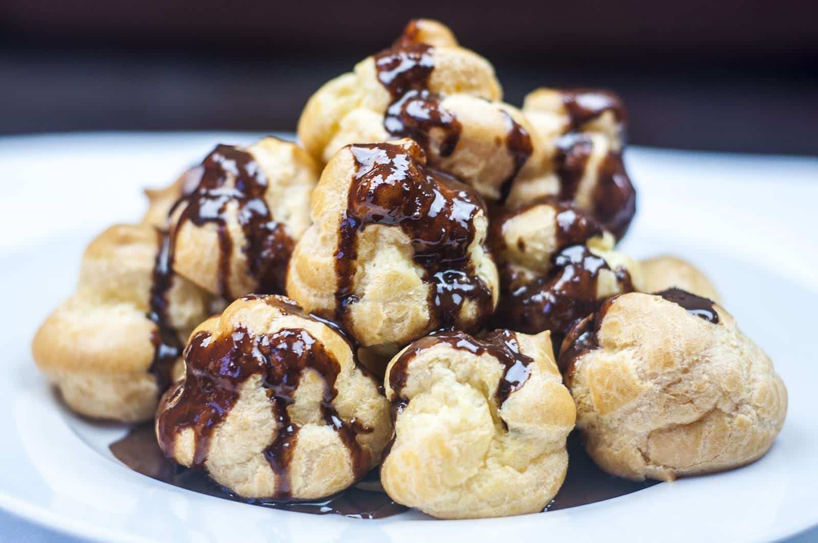 Profiteroles Recipe - How to make the finest profiteroles. Simple and easy. YOU can make them today. Choux buns, cream and chocolate! YUM! | https://theyumyumclub.com