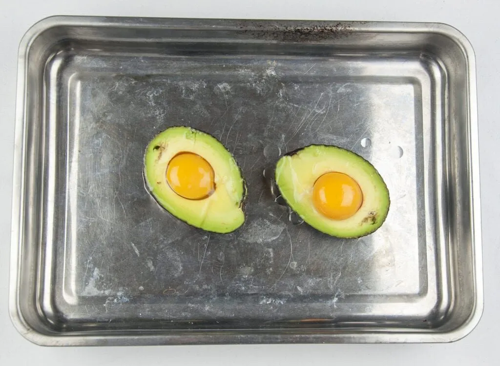 How to make avocado breakfast boats. Only a 3 ingredients recipe. Avocado, bacon, and eggs, and only 5 minutes preparation. Healthy and full of protein. What a great start to the day. Yum! | theyumyumclub.com