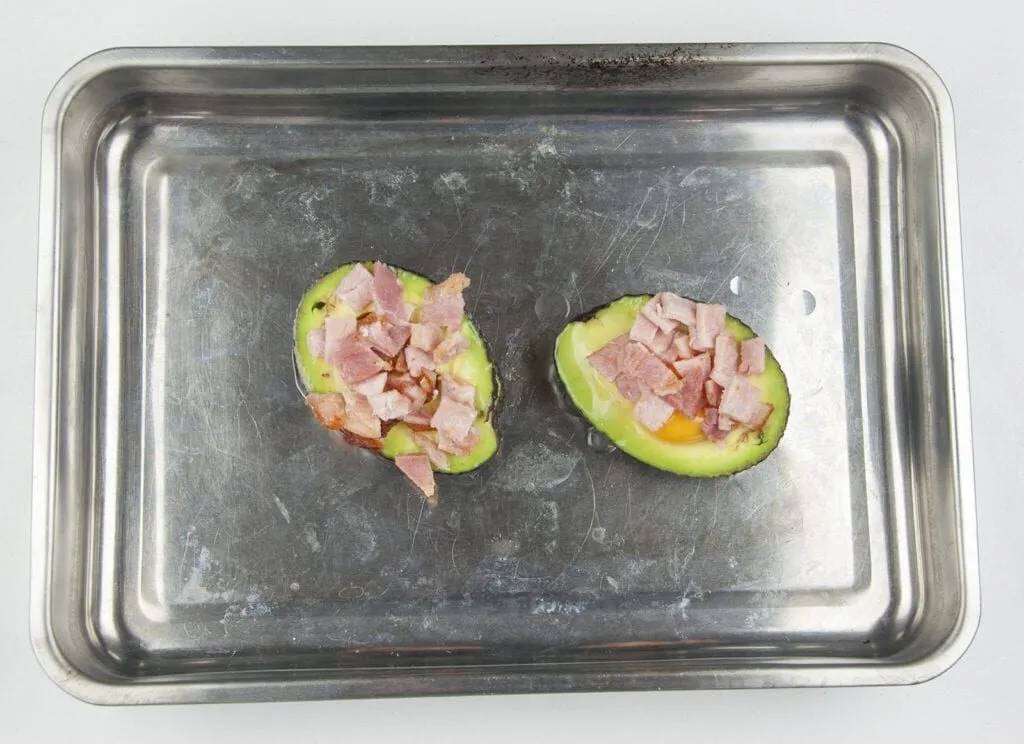 How to make avocado breakfast boats. Only a 3 ingredients recipe. Avocado, bacon, and eggs, and only 5 minutes preparation. Healthy and full of protein. What a great start to the day. Yum! | theyumyumclub.com