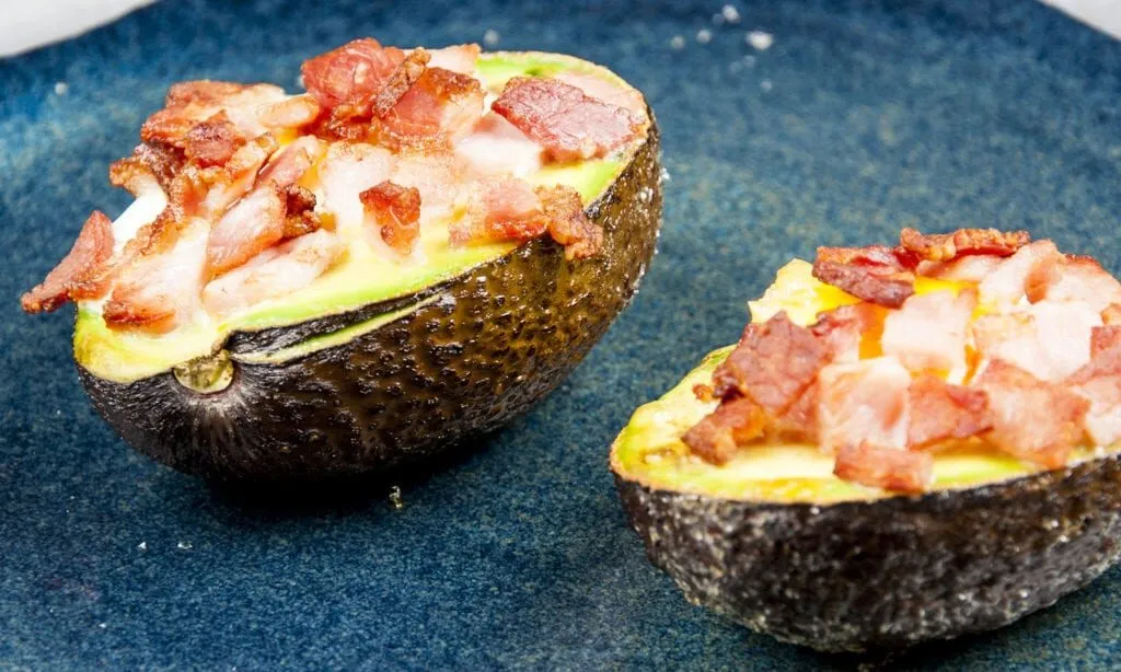 How to make avocado breakfast boats. Only a 3 ingredients recipe. Avocado, bacon, and eggs, and only 5 minutes preparation. Healthy and full of protein. What a great start to the day. Yum! | theyumyumclub.com