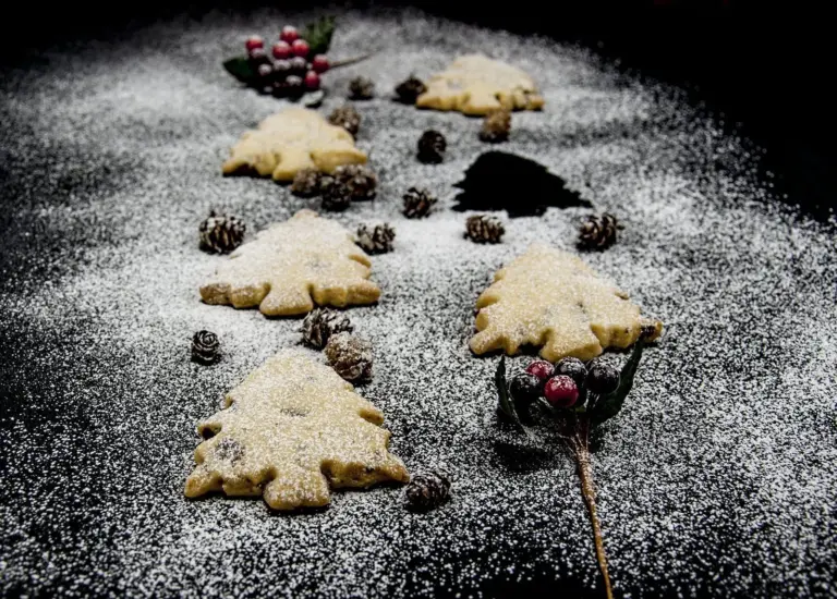 Don't these Christmas tree shortbreads look delicious. Icing sugar snow and Christmas decorations. Pack them up in Christmas wrapping or present them to be munched on at any time. A very simple Christmas recipe. Yum | theyumyumclub.com