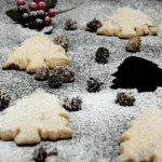 Don't these Christmas tree shortbreads look delicious. Icing sugar snow and Christmas decorations. Pack them up in Christmas wrapping or present them to be munched on at any time. A very simple Christmas recipe. Yum | theyumyumclub.com