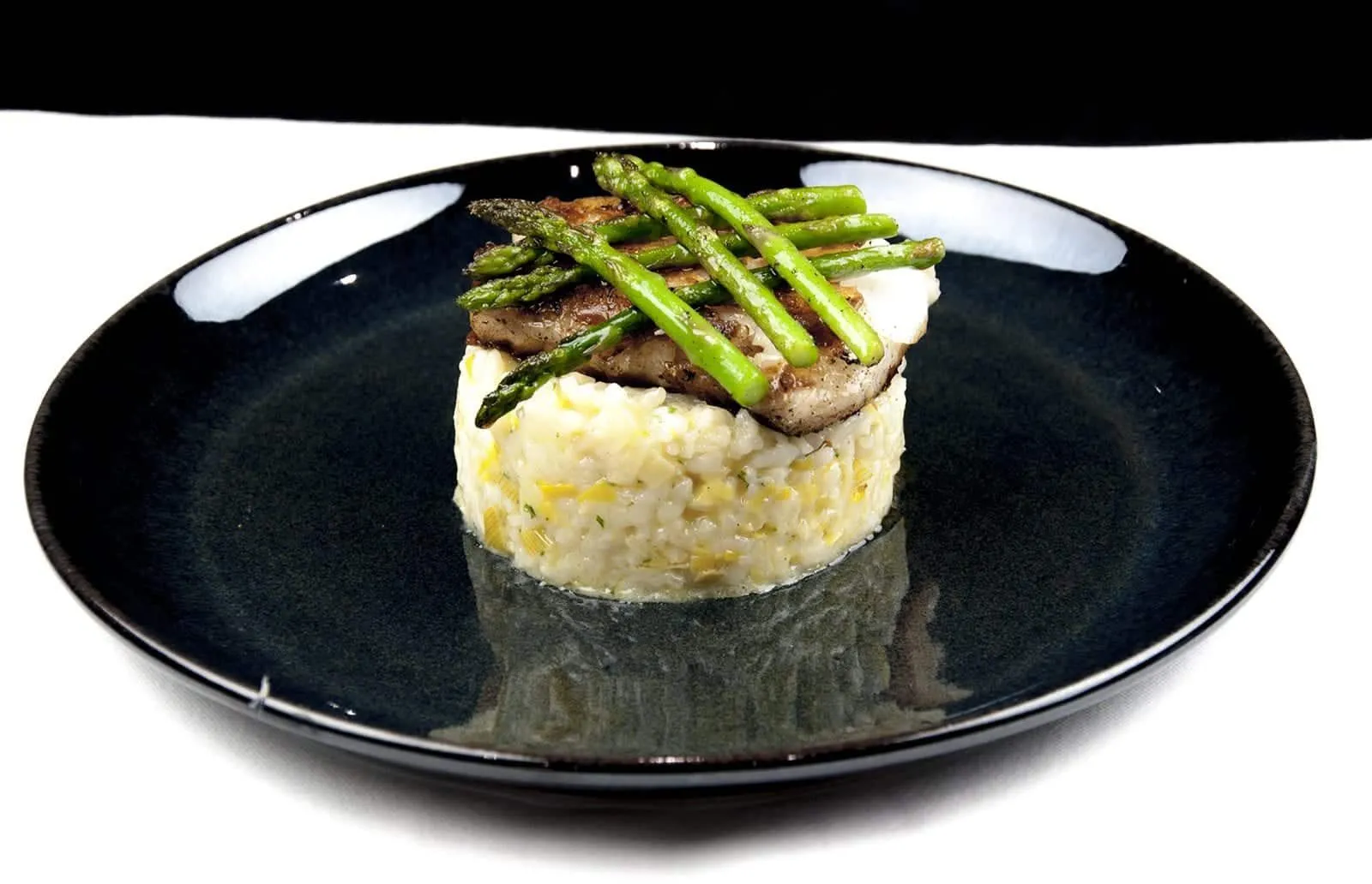 Pan fried cod on a bed of leek risotto served with asparagus | theyumyumclub