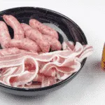 Pigs in blankets. Little pork chipolatas, wrapped in streaky bacon, and smothered in honey. The perfect accompaniment to Christmas Turkey. Yum! | theyumyumclub