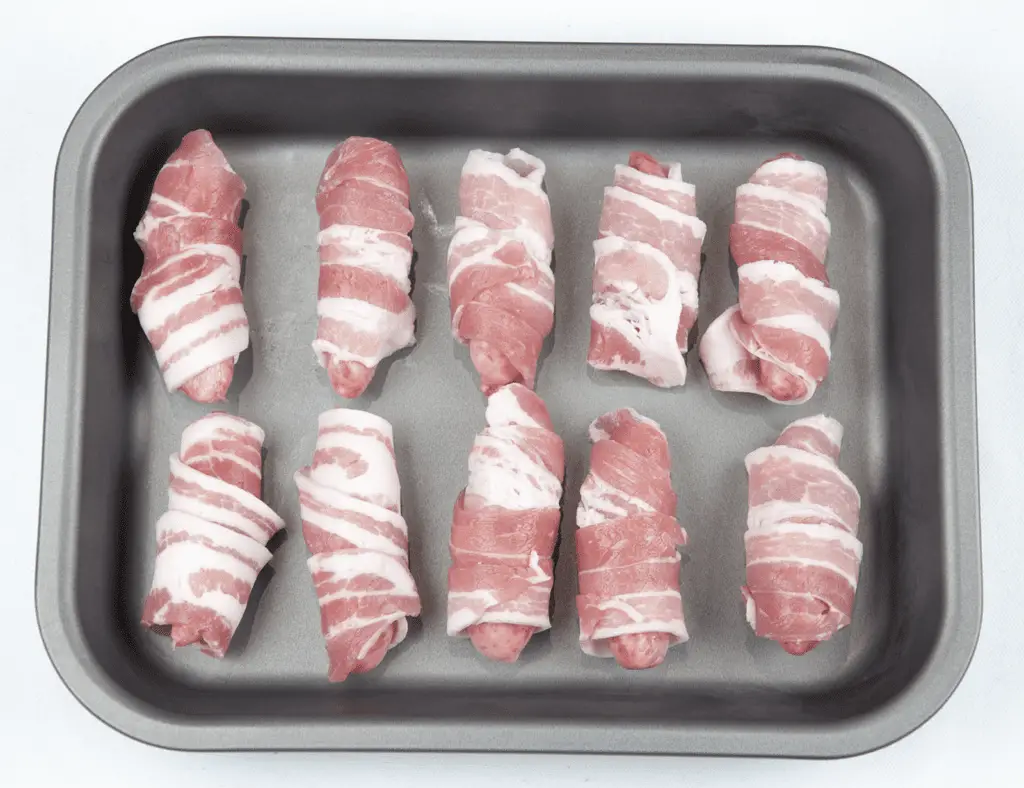 Pigs in blankets. Little pork chipolatas, wrapped in streaky bacon, and smothered in honey. The perfect accompaniment to Christmas Turkey. Yum! | theyumyumclub