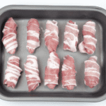 Pigs in blankets. Little pork chipolatas, wrapped in streaky bacon, and smothered in honey. The perfect accompaniment to Christmas Turkey. Yum! | theyumyumclub