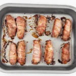 Pigs in blankets. Little pork chipolatas, wrapped in streaky bacon, and smothered in honey. The perfect accompaniment to Christmas Turkey. Yum! | theyumyumclub