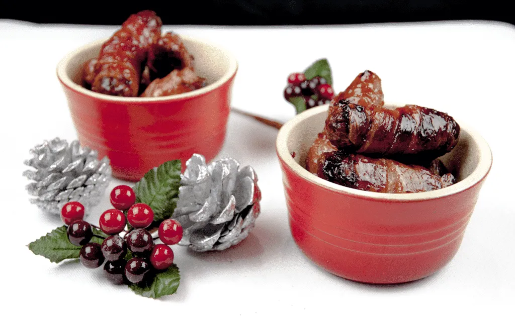 Pigs in blankets. Little pork chipolatas, wrapped in streaky bacon, and smothered in honey. The perfect accompaniment to Christmas Turkey. Yum! | theyumyumclub
