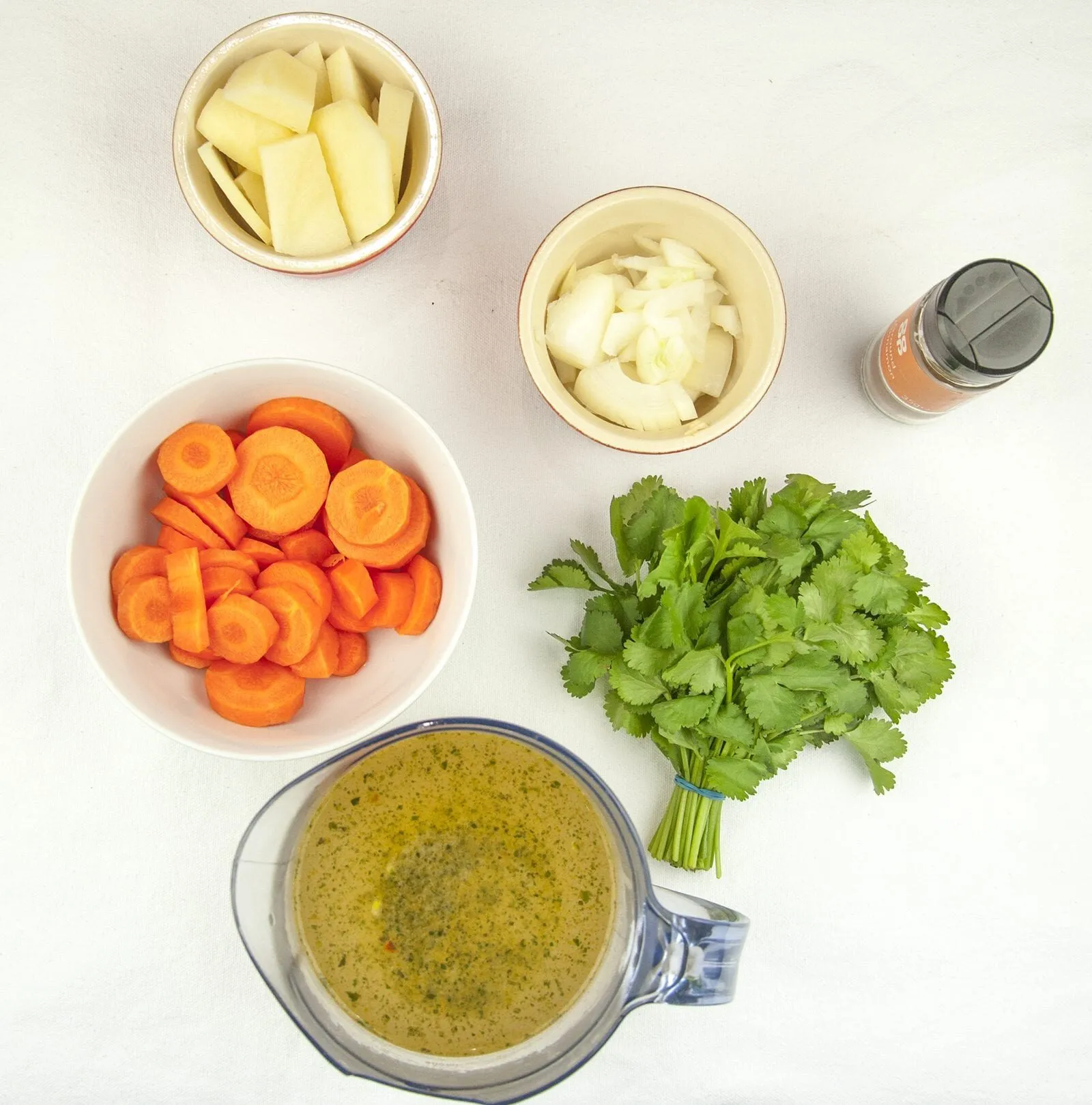 Carrot and coriander soup. A classic of a soup. Just 5 main ingredients! Carrot, coriander, potato, onion and vegetable stock. Suitable for vegetarians and vegans and only 156 calories per bowl! Yum! | theyumyumclub.com