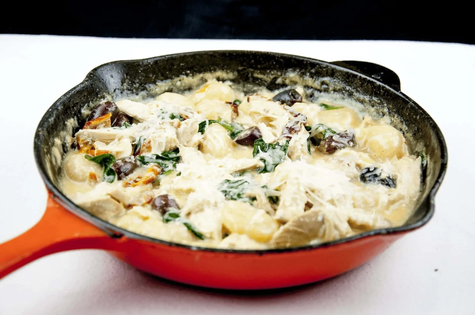 This creamy chicken gnocchi recipe brings the taste of Italy right to your own kitchen. Black olives. Sun-dried tomatoes. Baby spinach. Sounds good right? Yum! | theyumyumclub.com