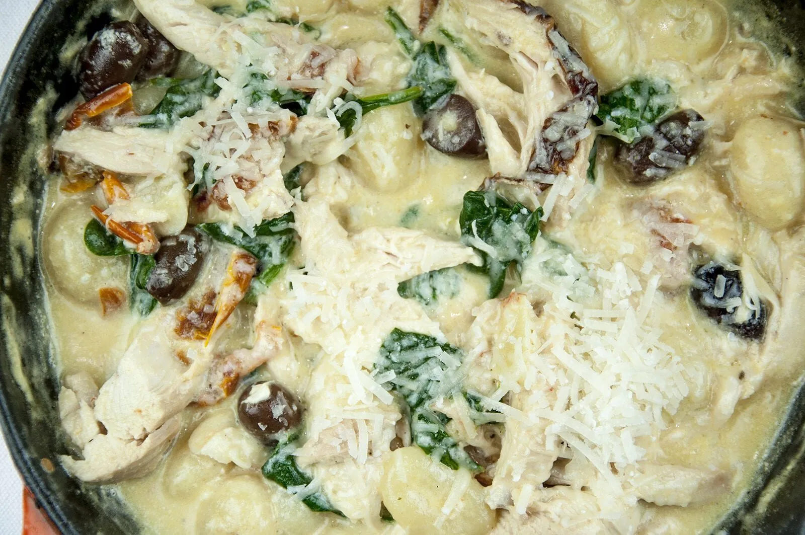 This creamy chicken gnocchi recipe brings the taste of Italy right to your own kitchen. Black olives. Sun-dried tomatoes. Baby spinach. Sounds good right? Yum! | theyumyumclub.com
