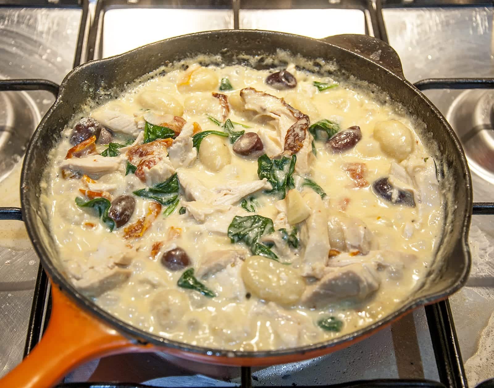 This creamy chicken gnocchi recipe brings the taste of Italy right to your own kitchen. Black olives. Sun-dried tomatoes. Baby spinach. Sounds good right? Yum! | theyumyumclub.com