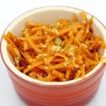 This spicy carrot, sesame and scallion salad is so simple and so healthy. 3 ingredients for the salad, 4 ingredeints for the spicy dressing, and just over 200 calories per bowl. Yum! | theyumyumclub.com