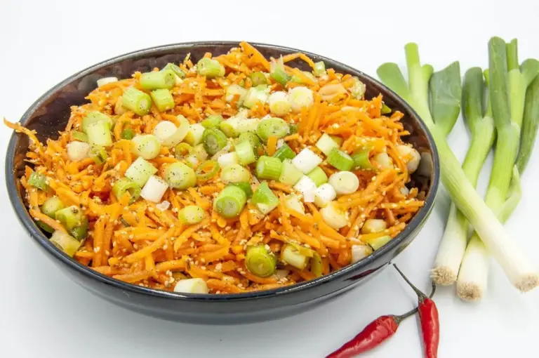 This spicy carrot, sesame and scallion salad is so simple and so healthy. 3 ingredients for the salad, 4 ingredeints for the spicy dressing, and just over 200 calories per bowl. Yum! | theyumyumclub.com