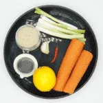 This spicy carrot, sesame and scallion salad is so simple and so healthy. 3 ingredients for the salad, 4 ingredeints for the spicy dressing, and just over 200 calories per bowl. Yum! | theyumyumclub.com