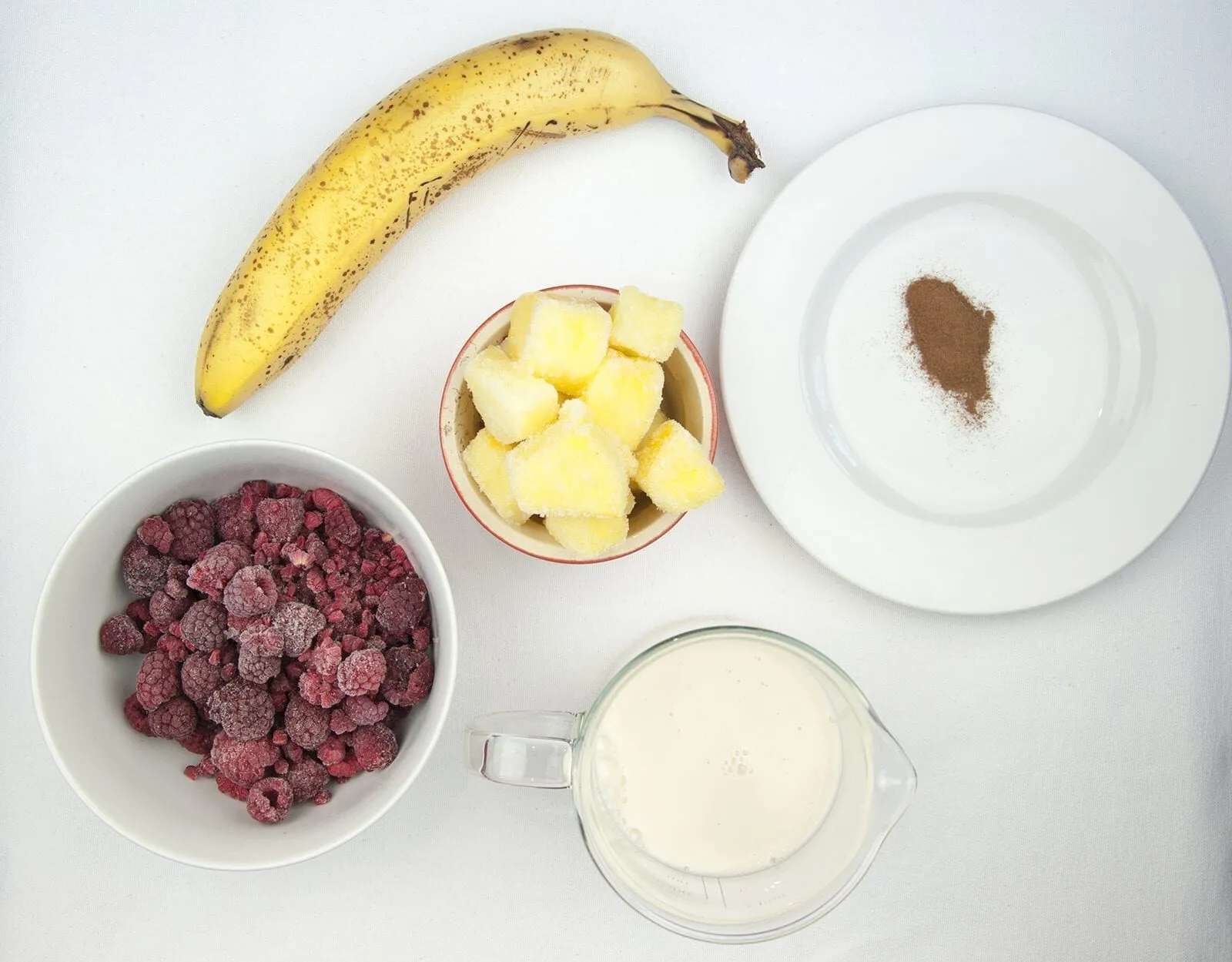 Raspberry and pineapple smoothie, with a little surprise! Banana to add texture and a wonderful hint of cinnamon to taste. A great start to the day. Yum! | theyumyumclub.com