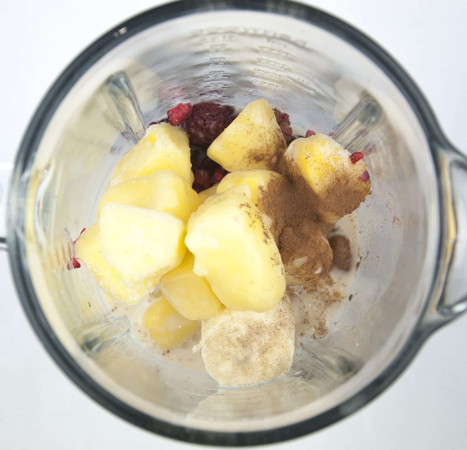 Raspberry and pineapple smoothie, with a little surprise! Banana to add texture and a wonderful hint of cinnamon to taste. A great start to the day. Yum! | theyumyumclub.com