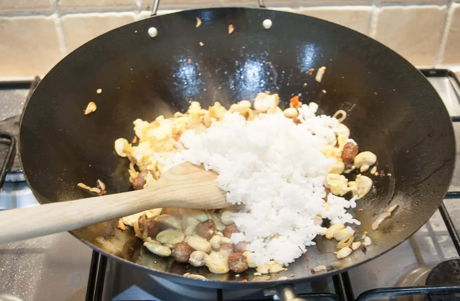 This Thai style sausage fried rice is a fusion of the best from East and West. Cashews, chilli, garlic, basil, coriander and sweet smelling saffron. Yum! | theyumyumclub.com