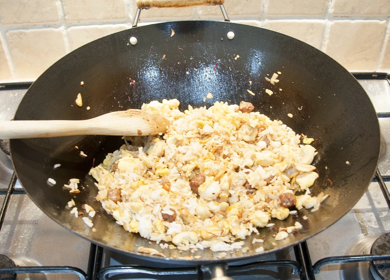 This Thai style sausage fried rice is a fusion of the best from East and West. Cashews, chilli, garlic, basil, coriander and sweet smelling saffron. Yum! | theyumyumclub.com