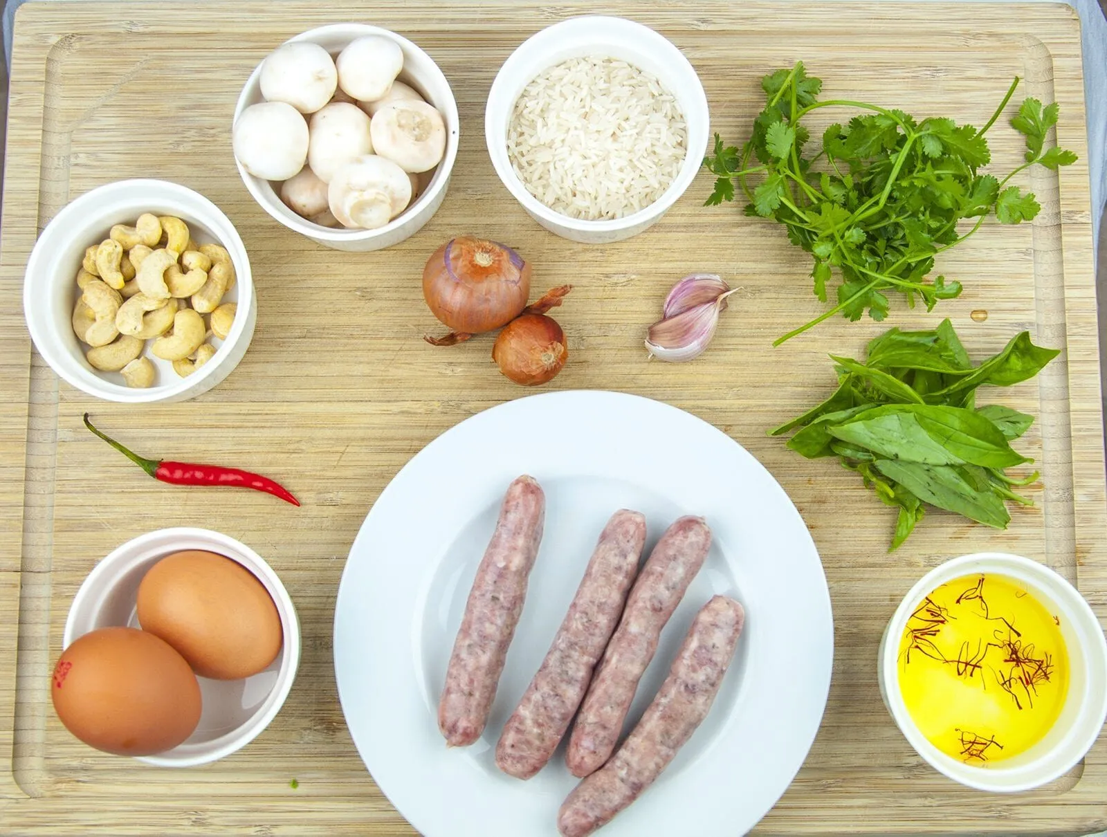 This Thai style sausage fried rice is a fusion of the best from East and West. Cashews, chilli, garlic, basil, coriander and sweet smelling saffron. Yum! | theyumyumclub.com
