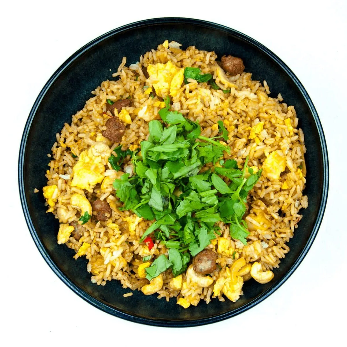 This Thai style sausage fried rice is a fusion of the best from East and West. Cashews, chilli, garlic, basil, coriander and sweet smelling saffron. Yum! | theyumyumclub.com