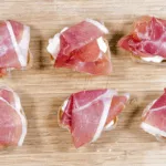Layer the prosciutto | https://theyumyumclub.com/2019/04/23/ricotta-prosciutto-fig-crostini/