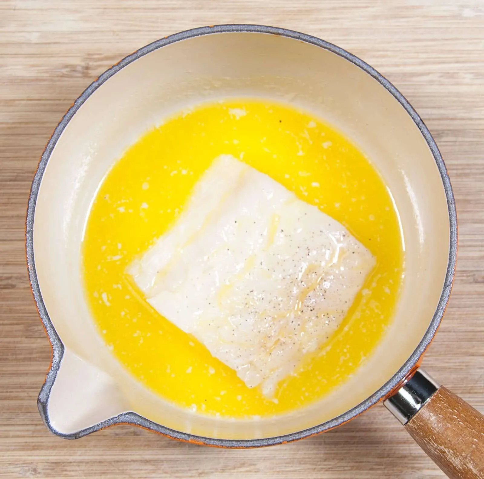 Parmesan & Paprika Haddock Baked in Garlic Butter. Dip the fish in the butter | https://theyumyumclub.com/2019/04/29/parmesan-paprika-haddock-garlic-butter/