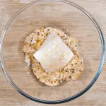 Parmesan & Paprika Haddock Baked in Garlic Butter. Dip the fish in the coating | https://theyumyumclub.com/2019/04/29/parmesan-paprika-haddock-garlic-butter/