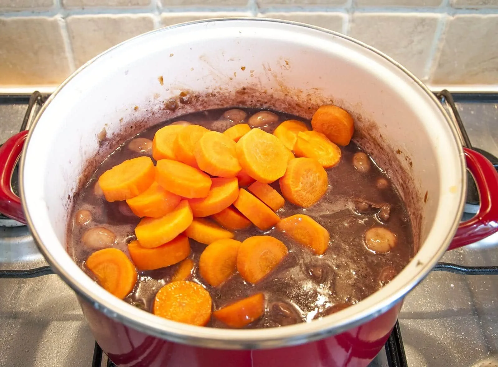 Braised beef rump in red wine. Add the beef stock and carrots | https://theyumyumclub.com/2019/05/08/braised-beef-rump-red-wine/