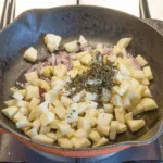 Streaky & apple pork tenderloin. Add the apples, onion, and thyme | https://theyumyumclub.com/2019/05/19/streaky-apple-pork-tenderloin/