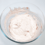Fluffy and creamy strawberry mousse. Fold the strawberries into the cream. | https://theyumyumclub.com/2019/05/10/fluffy-creamy-strawberry-mousse/