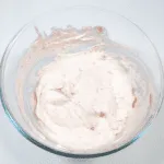Fluffy and creamy strawberry mousse. Fold the strawberries into the cream. | https://theyumyumclub.com/2019/05/10/fluffy-creamy-strawberry-mousse/