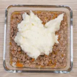 Cheddar topped shepherd's pie. Spoon to the potato onto the lamb | https://theyumyumclub.com/2019/05/16/cheddar-topped-shepherds-pie/