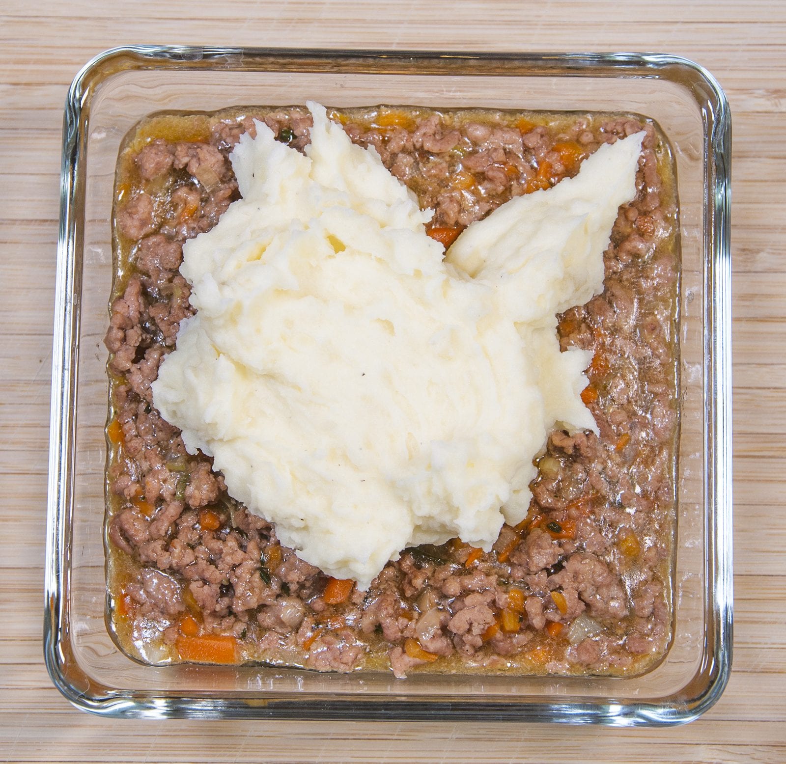 Cheddar topped shepherd's pie. Spoon to the potato onto the lamb | https://theyumyumclub.com/2019/05/16/cheddar-topped-shepherds-pie/