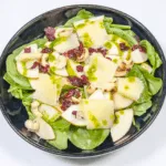 Drizzle the dressing | https://theyumyumclub.com/2019/06/10/cashew-cranberry-comte-fruit-salad/