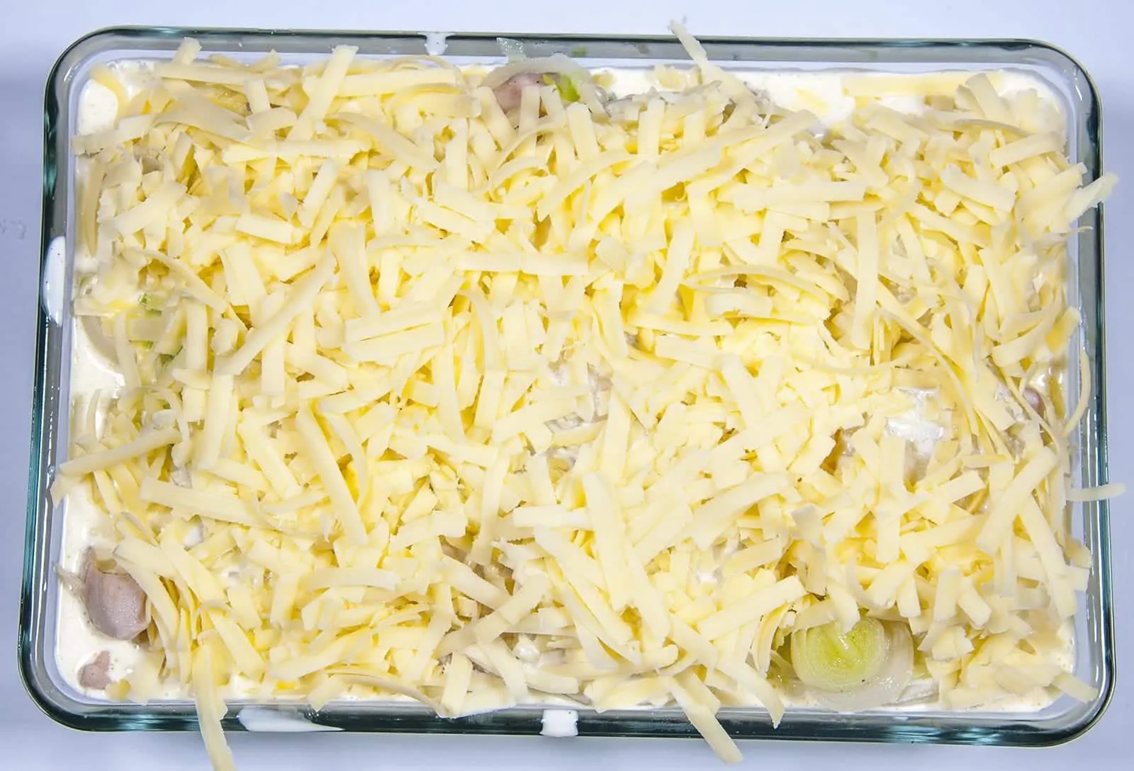 Chicken and Leek Dauphinoise. Pour over the cream and garlic mixture | https://theyumyumclub.com/2019/06/03/chicken-leek-dauphinoise/