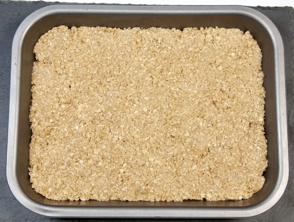 Flatten the flapjack mixture | https://theyumyumclub.com/2019/06/01/extra-soft-and-chewy-flapjacks/