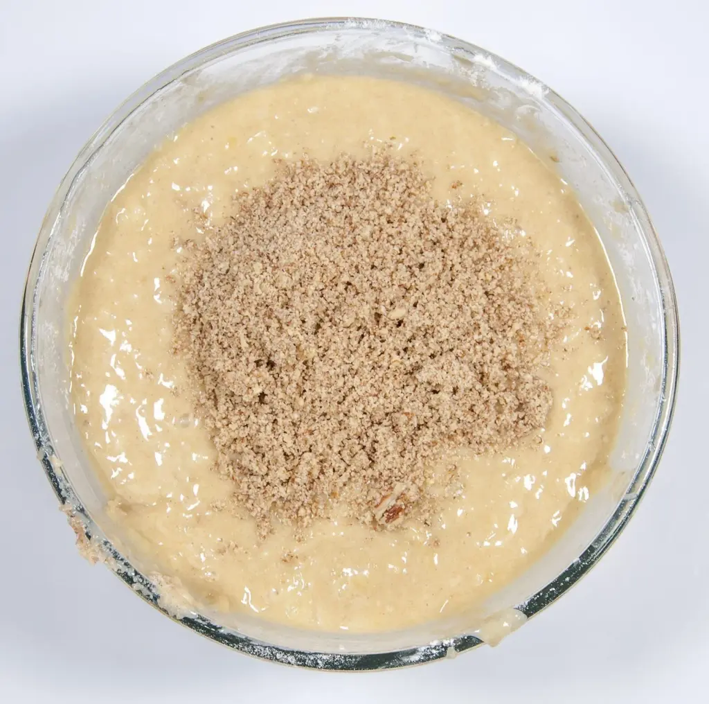 Add the chopped pecans. Humble Hummingbird Cake With Sweet Pecan Dust | https://theyumyumclub.com/2019/06/05/humble-hummingbird-cake-sweet-pecan-dust/