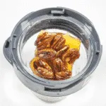 Add the pecan brittle to a blender. Humble Hummingbird Cake With Sweet Pecan Dust | https://theyumyumclub.com/2019/06/05/humble-hummingbird-cake-sweet-pecan-dust/