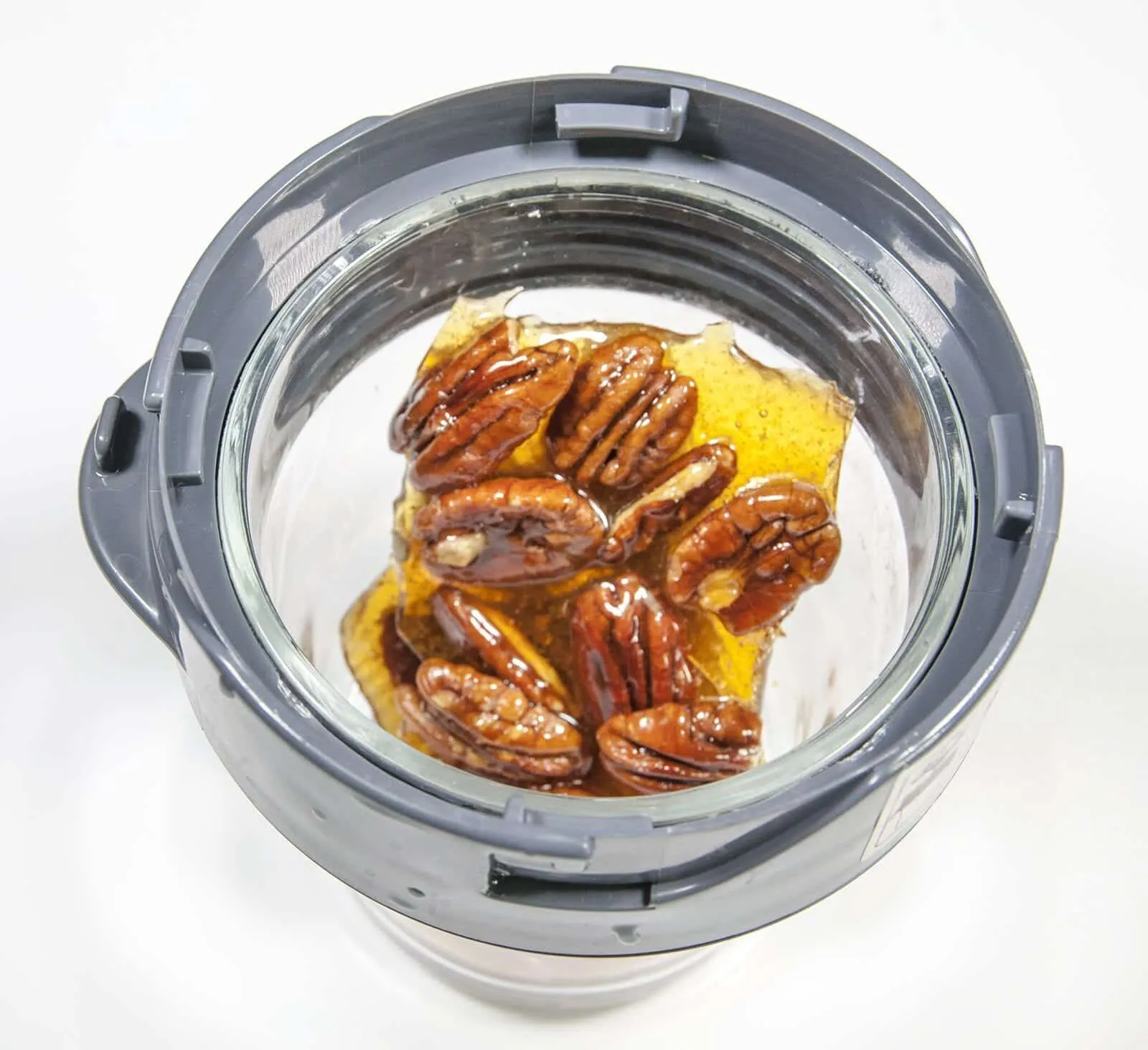 Add the pecan brittle to a blender. Humble Hummingbird Cake With Sweet Pecan Dust | https://theyumyumclub.com/2019/06/05/humble-hummingbird-cake-sweet-pecan-dust/