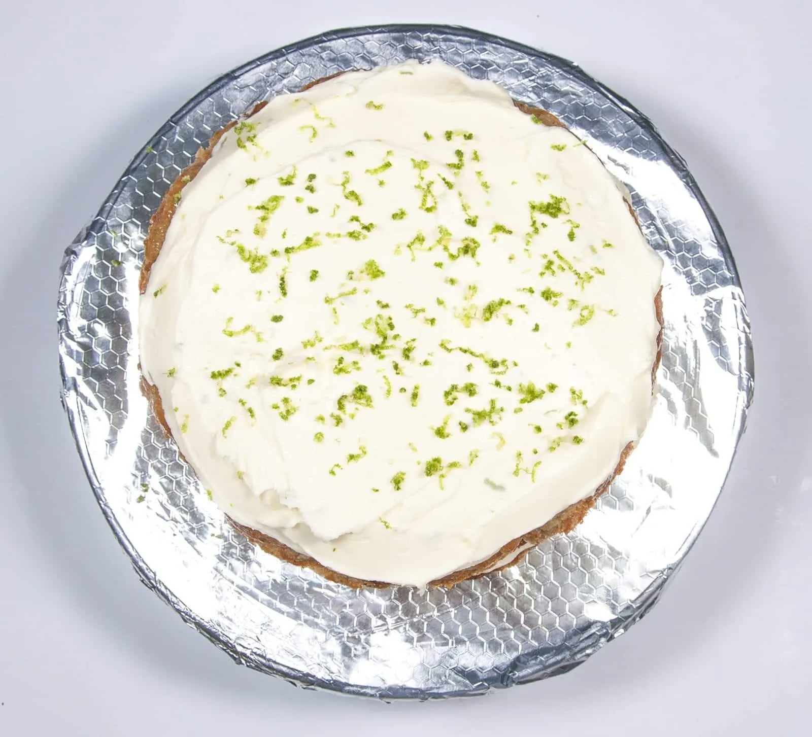 Grate over some line zest. Humble Hummingbird Cake With Sweet Pecan Dust | https://theyumyumclub.com/2019/06/05/humble-hummingbird-cake-sweet-pecan-dust/