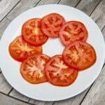 Lay out the tomato on the serbing plate | https://theyumyumclub.com/2019/07/25/burrata-bull-tomato-salad/