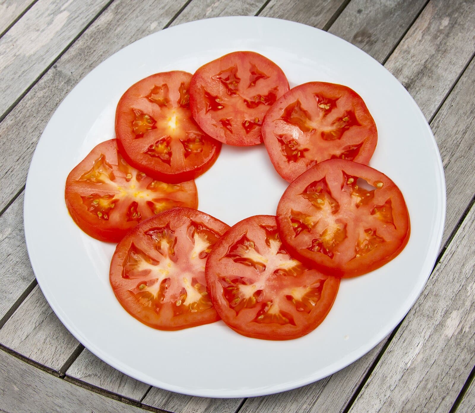 Lay out the tomato on the serbing plate | https://theyumyumclub.com/2019/07/25/burrata-bull-tomato-salad/