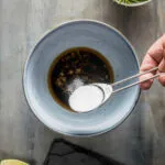 Place chopped ginger, sesame oil, soy sauce, and sugar in a small bowl.